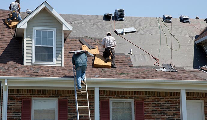 Persons repairing the roof with equipment