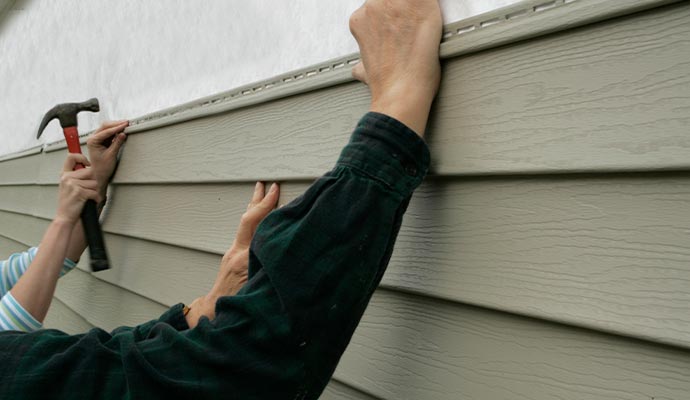 Person installing vinyl siding